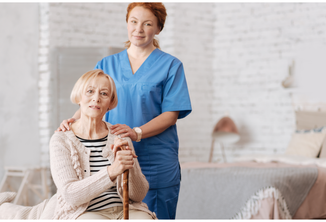 Home care worker standing behind an elderly woman in her home as they look into the camera.